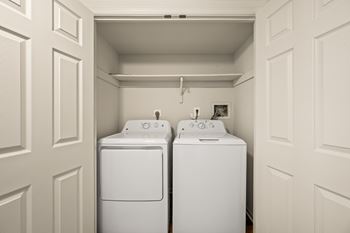 Two white washing machines in a laundry room.